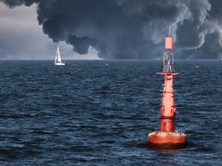 Red buoy on water in a stormy day. - obrazy, fototapety, plakaty
