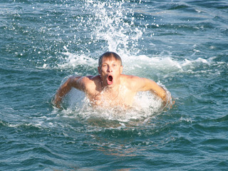 Man swims in the sea waves.