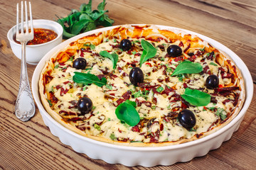 Pizza homemade with sauce on wooden background