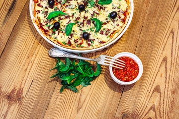 Pizza homemade with sauce on wooden background 