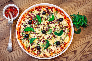 Pizza homemade with sauce on wooden background 