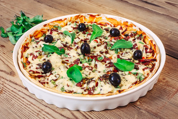 Pizza homemade with arugula on wooden background