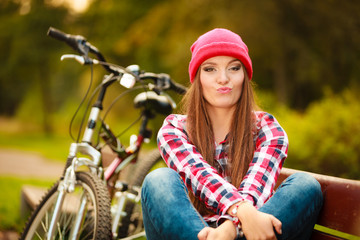 girl relaxing in autumnal park with bicycle.