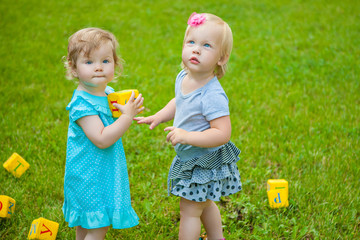 Little girls on nature playing toy