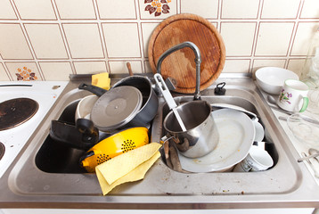 Spüle mit dreckigem Geschirr und Lappen in alter Küche