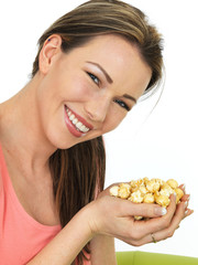 Attractive Young Happy Woman Holding A Handful Of Toffee Coated Popcorn