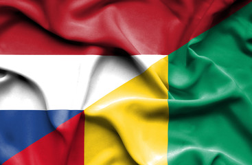 Obraz premium Waving flag of Guinea and Netherlands