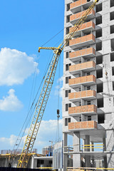 Crane and building construction site against blue sky