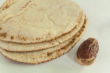 Arabic Kuboos bread and dates fruit on white background