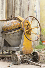 Concrete mixer with a wheel for pouring ready-mixed concrete onto a tray. The mixer is driven by an...