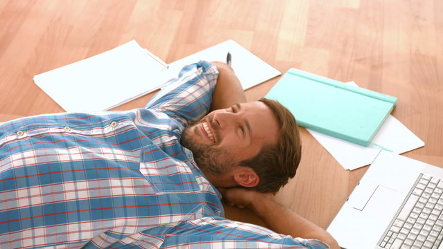 Happy handsome man lying on floor 