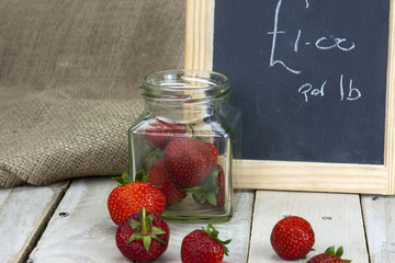 Stawberries in a jar and spilt on table