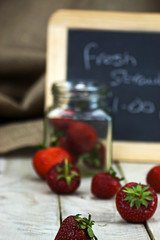 Stawberries in a jar and spilt on table