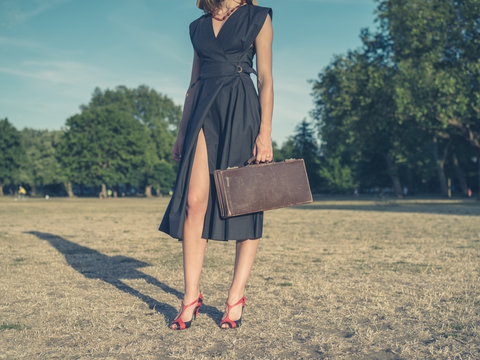 Young woman with briefcase in park