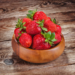 Strawberries in a bowl on old boards