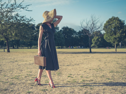 Elegant woman walking in park with briefcase