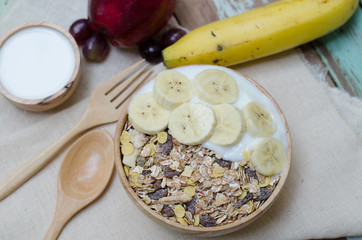breakfast : home made yogurt with oat flakes in bowl on wooden t