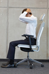 yoga with chair in office - business man exercising