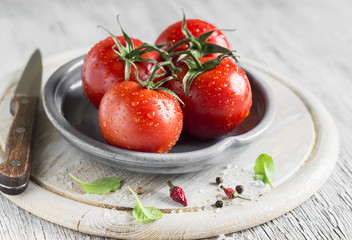 fresh tomatoes on a vintage plate on a light wooden background