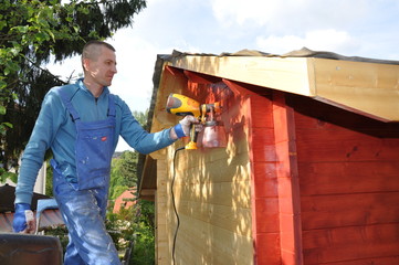 Mann streicht Schuppen mit roter Farbe