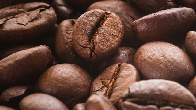 A pile of roasted coffee beans rotating. Close up