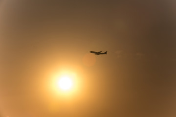 airplane in front of a hot evening sun