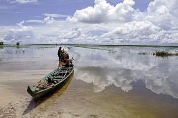 Obraz premium Farmer working in the rice field with beautiful reflection of the sky