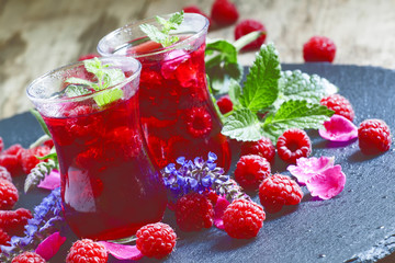 Hot red tea with raspberries, mint and rose petals, selective fo