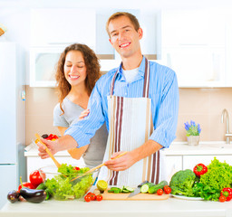 Happy couple cooking together in their kitchen