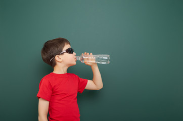 boy with water bottle and school board