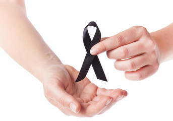 Black ribbon held in female hands on white background