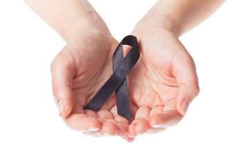 Black ribbon held in two female hands on white background