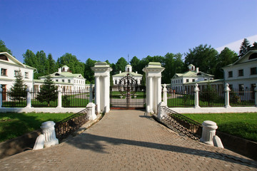 Fototapeta na wymiar White front gate of the countryside manor