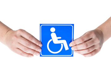 A white and blue symbol of disabled people held in both female hands on a white background