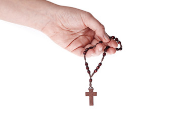 A female hand holding brown rosary on a white background