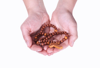 Two female hands holding tangled wooden rosary on a white background