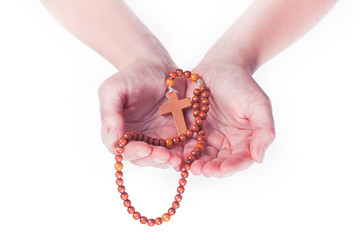 Two female hands holding brown rosary on a white background