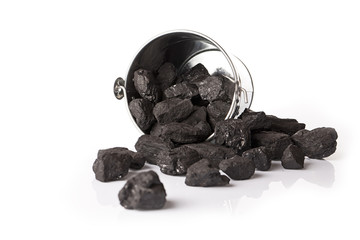 Silver bucket with lumps of black coal on a white background and glossy table