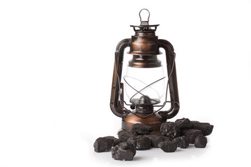 Old mining lamp with loose lumps of black coal on white background