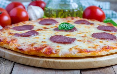 Homemade pepperoni pizza on a wooden board, ready to eat
