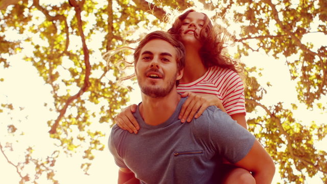 Handsome man doing piggy-back to his girlfriend 