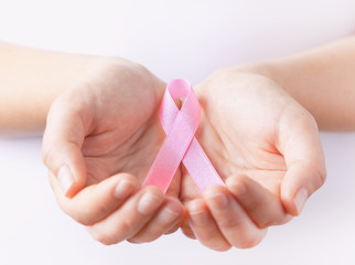 hands holding pink breast cancer awareness ribbon
