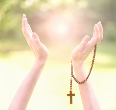 Christian prayer beads in the hand of woman 