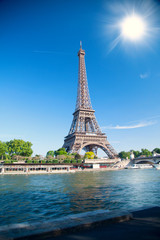 Naklejka na ściany i meble summer day the sun shines over the Eiffel Tower symbol of Paris.