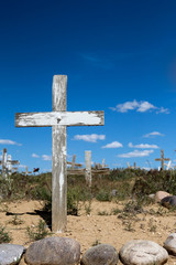Weathered and old cross at an overgrown New Mexican mission cemetery