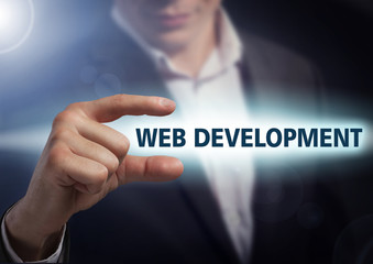 Businessman presses button web development on virtual screens. B
