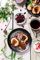 pancakes with berries on wooden table.