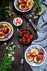Fototapeta na wymiar Pancakes with wild berries on dark wooden table.
