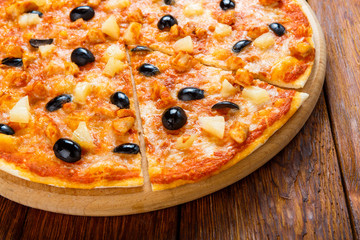 Delicious pizza with pineapple, chicken and olives