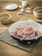 Raw chicken and ingredient  in bowl on wooden table